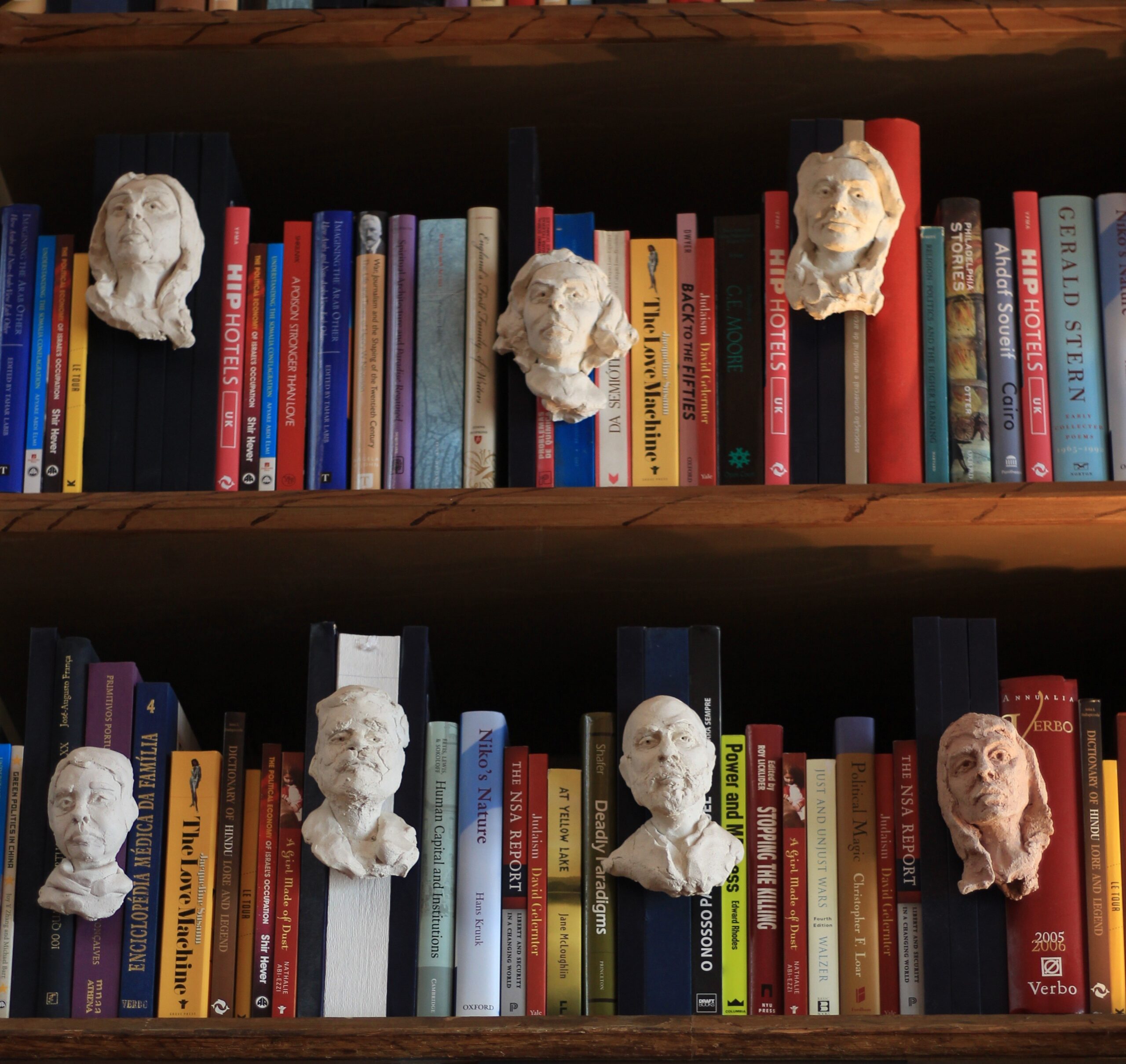 Wooden bookshelf with plaster busts and books
