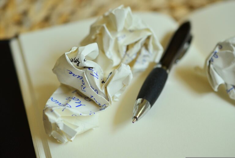 Crumpled paper balls and pen on notebook